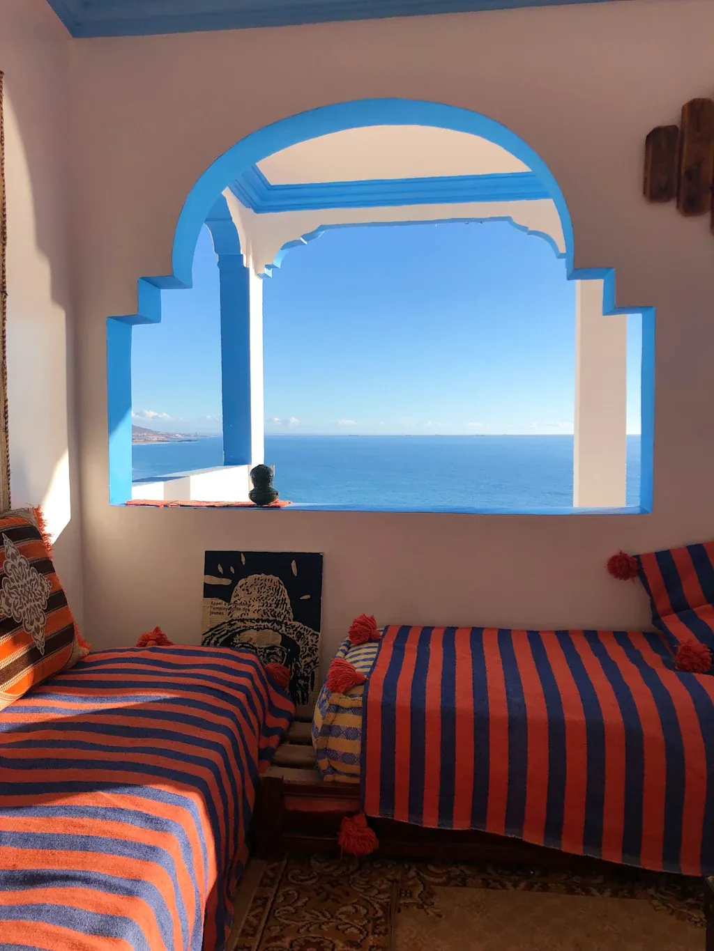 Cozy lounge with ocean view through Moroccan arch window